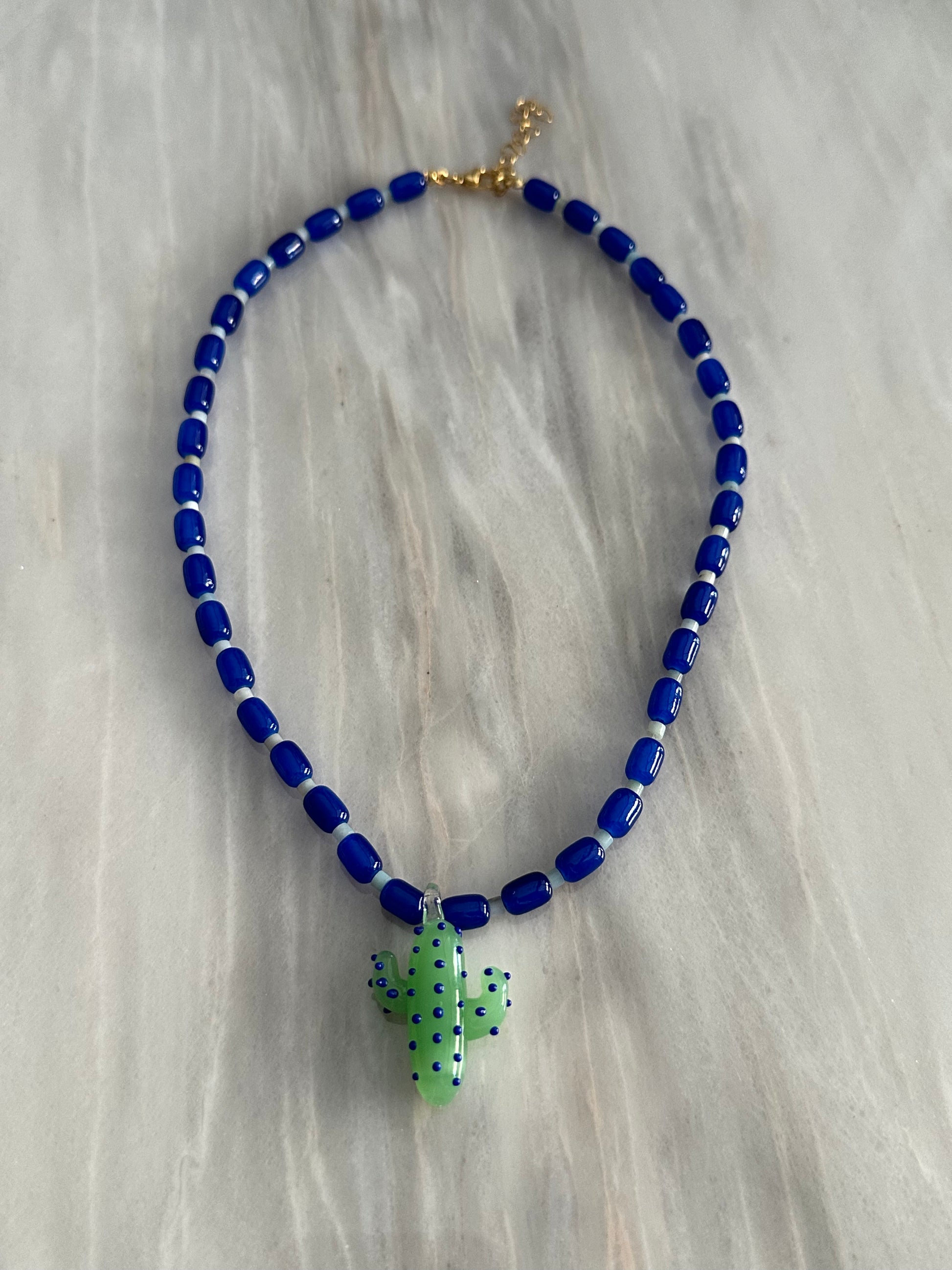 Collar hecho a mano con cuentas de cerámica azul y piedra agata de arbol con un abalorio con forma de cactus de cristal de murano en tono verde con puntos azules