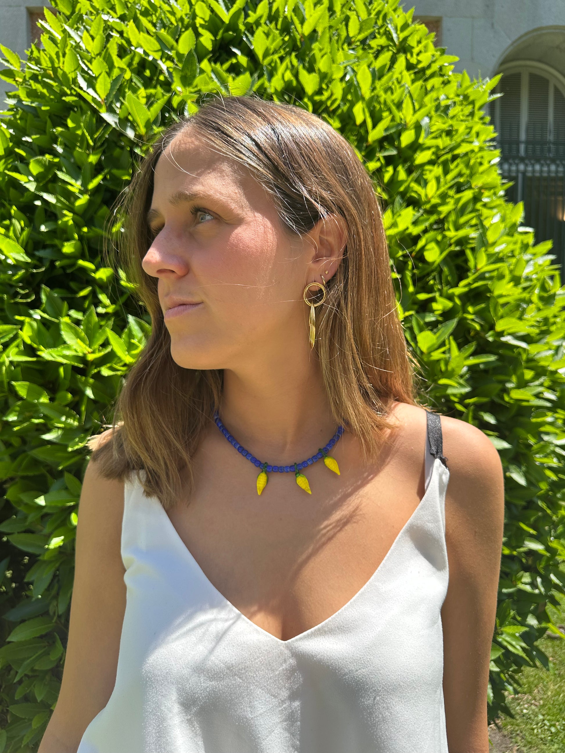 Collar hecho a mano con cuentas de cerámica azul y con tres abalorios con forma de mazorcas de maíz de cristal de murano en color amarillo. Cierre ajustable de acero inoxidable