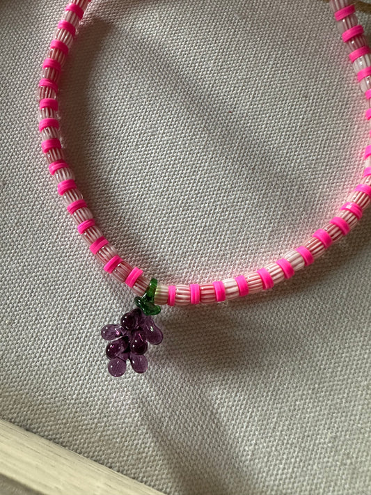 Collar hecho a mano con cuentas de cerámica blancas y  arcilla polimérica rosa con un abalorio con forma de racimo de uvas de cristal de murano. Cierre ajustable de acero inoxidable