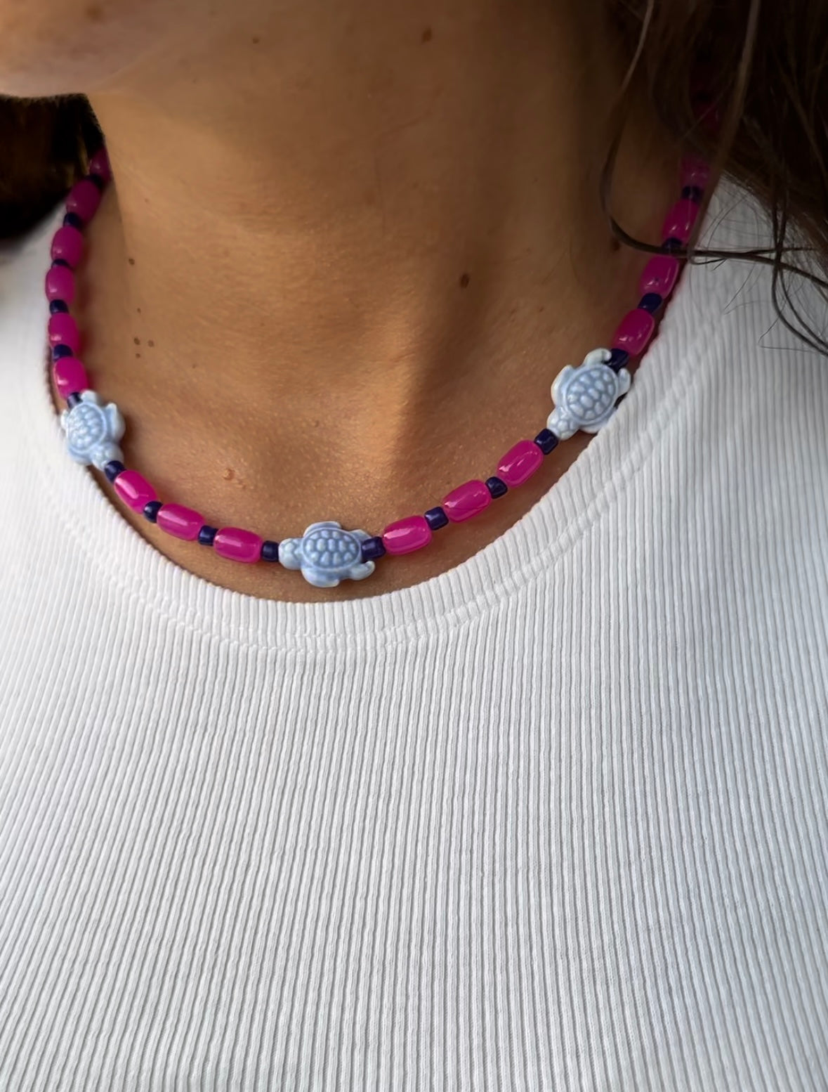 Collar hecho a mano con cuentas de cerámica rosas, cuentas azules y con 3 tortugas de cerámica. Cierre ajustable de acero inoxidable.