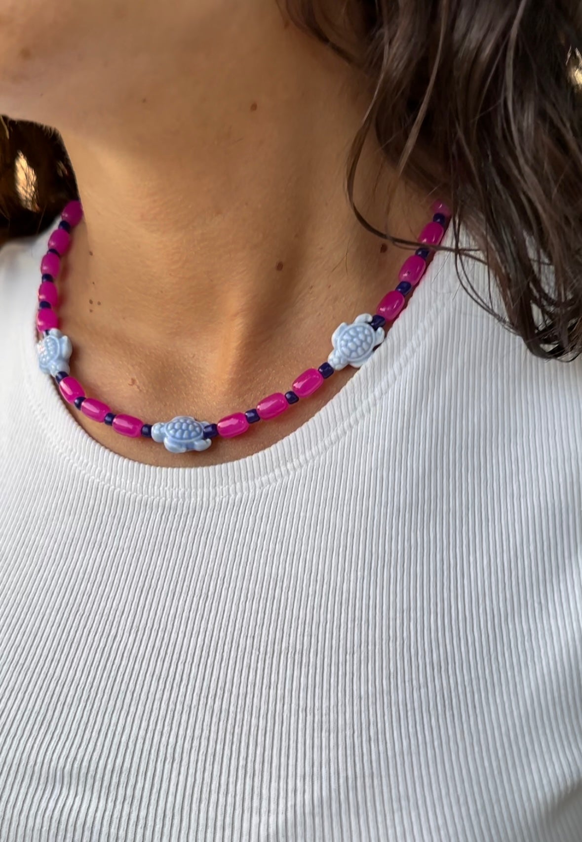 Collar hecho a mano con cuentas de cerámica rosas, cuentas azules y con 3 tortugas de cerámica. Cierre ajustable de acero inoxidable.