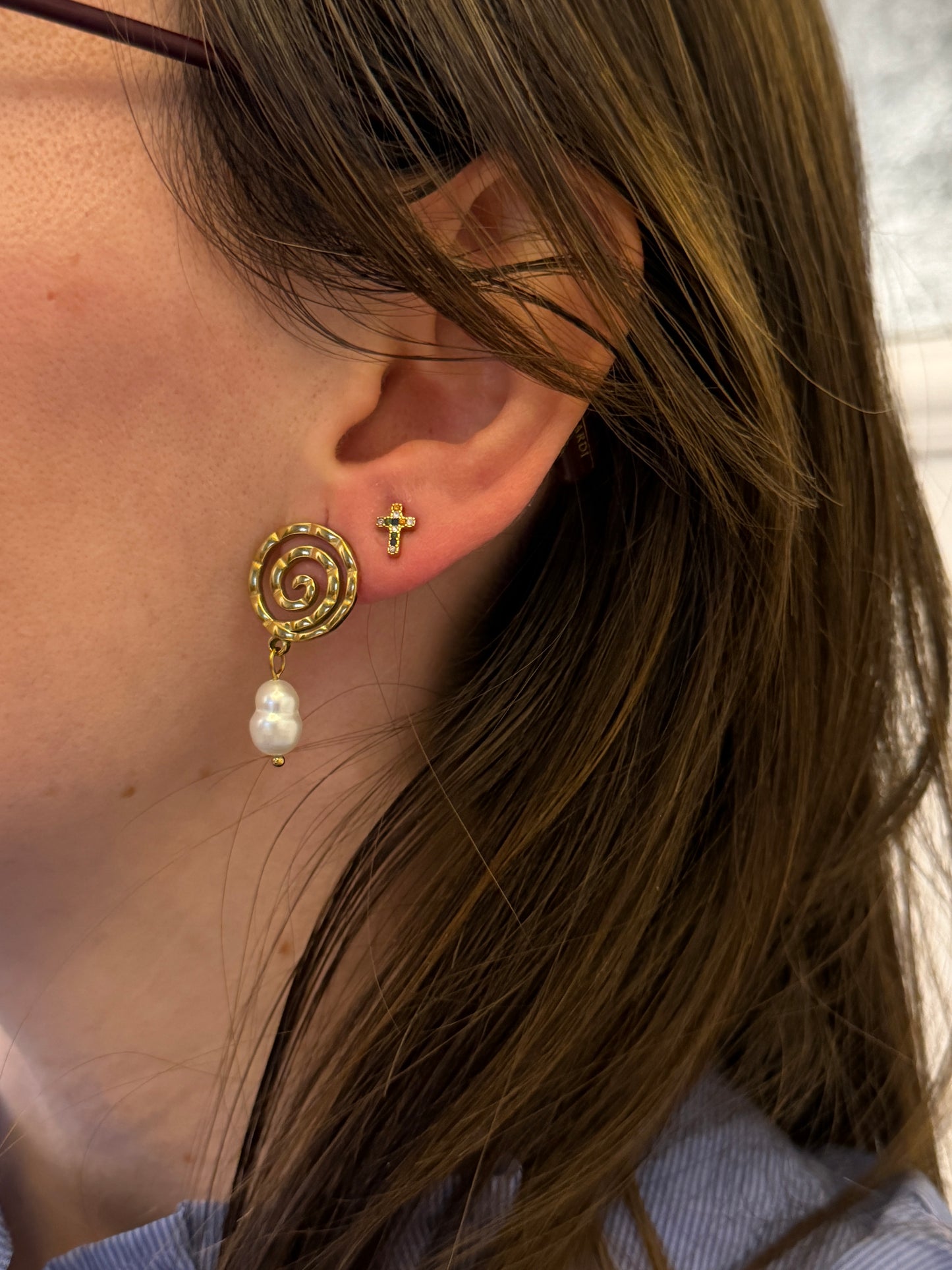 Pendientes de acero inoxidable en color plateado con espiral y una perla. Estos pendientes son perfectos para elevar tus looks. 