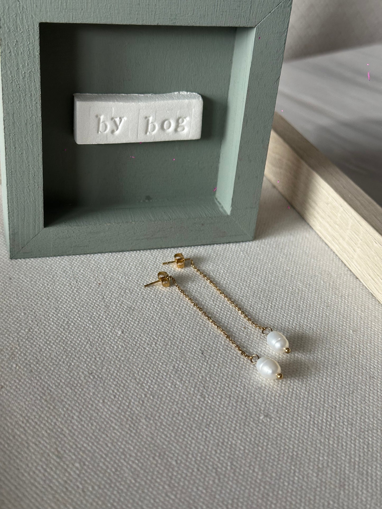 Pendientes largos de acero inoxidable en color dorado con perla de río colgando. Estos pendientes son perfectos para elevar tus looks. 