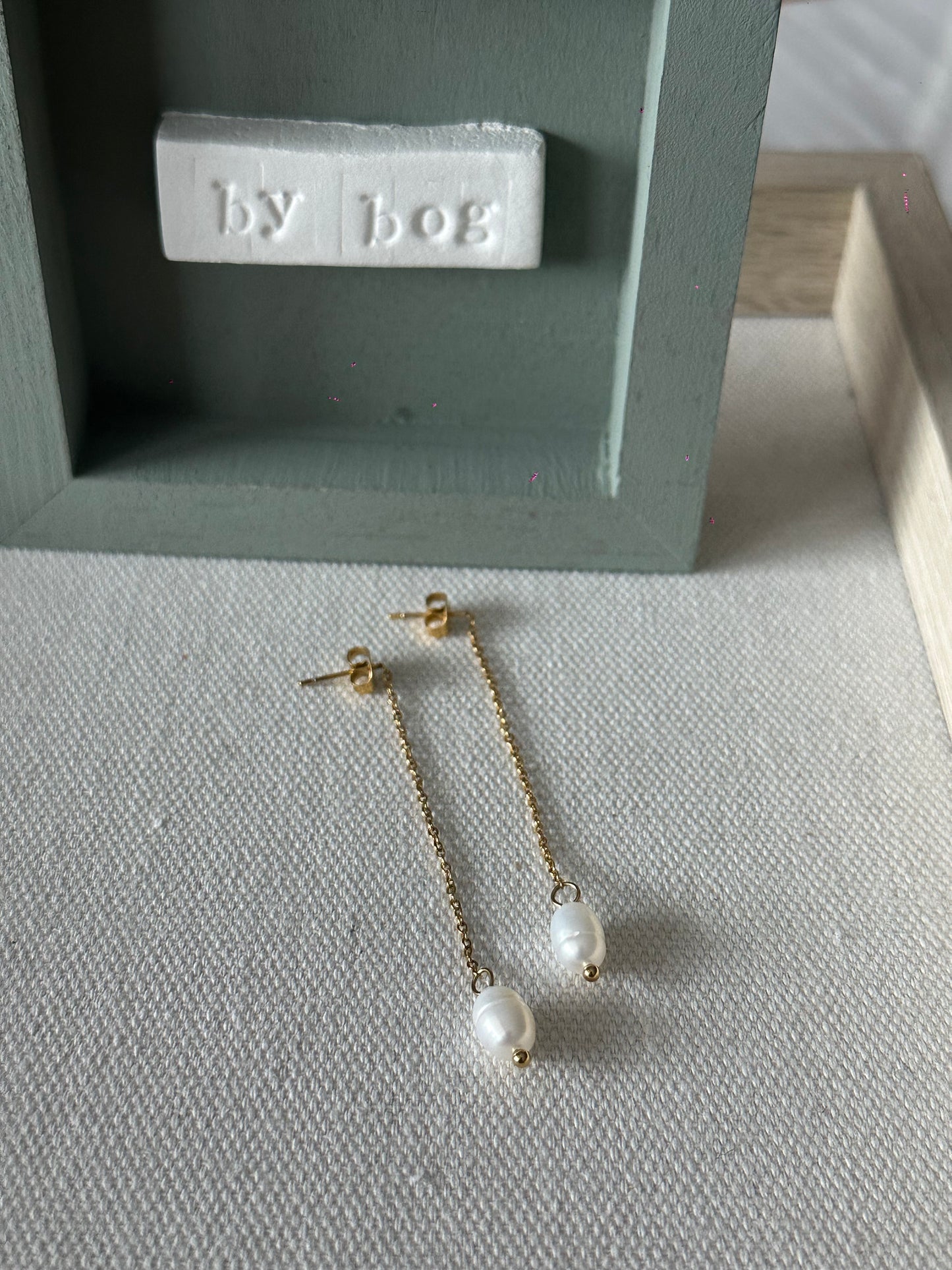 Pendientes largos de acero inoxidable en color dorado con perla de río colgando. Estos pendientes son perfectos para elevar tus looks. 