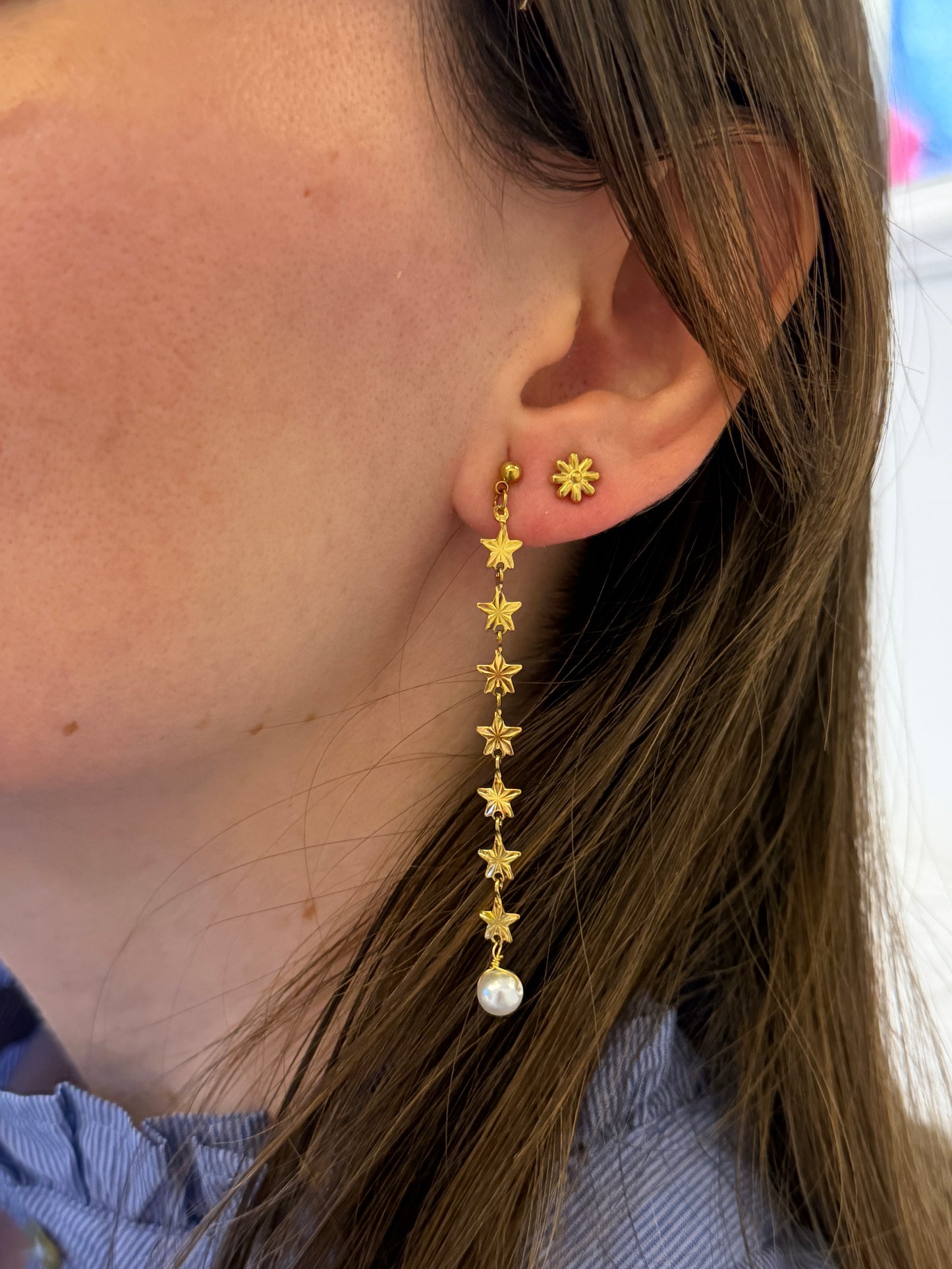 Pendientes de acero inoxidable largos con estrellas doradas y una perla. Estos pendientes son perfectos para elevar tus looks. 