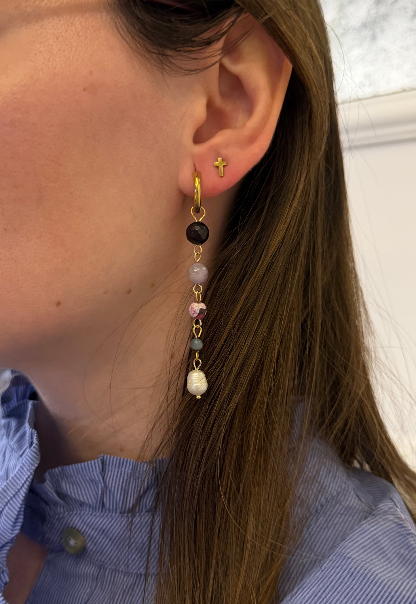 Pendientes de acero inoxidable en color dorado largos con piedras de colores y una perla. Estos pendientes son perfectos para elevar tus looks. 