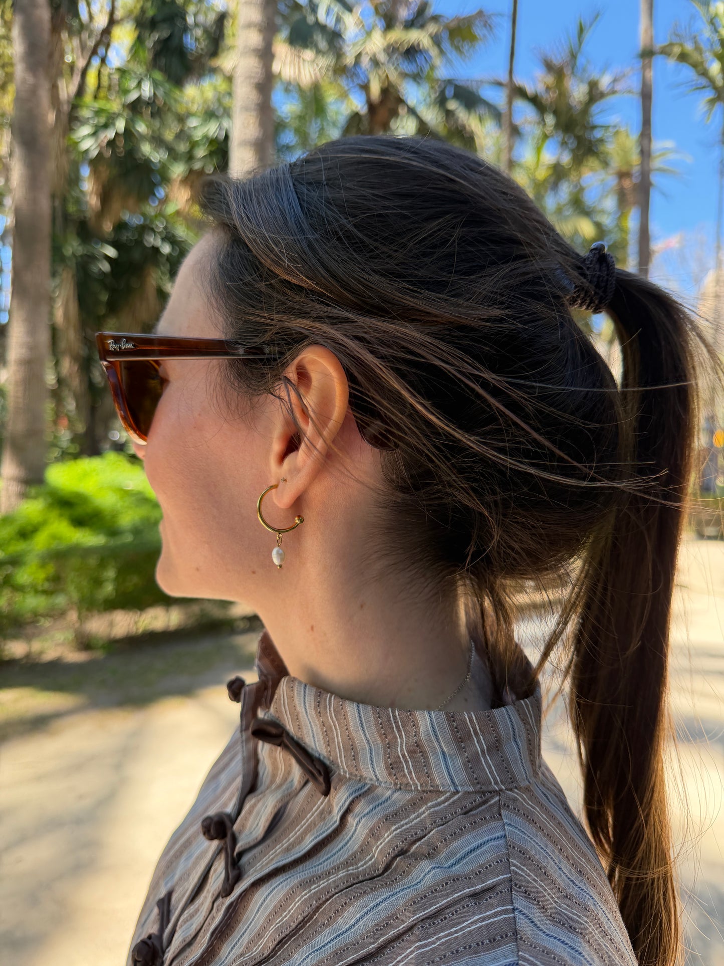 Pendientes de aro de acero inoxidable en color dorado con perla de río colgando. Estos pendientes son perfectos para elevar tus looks. 