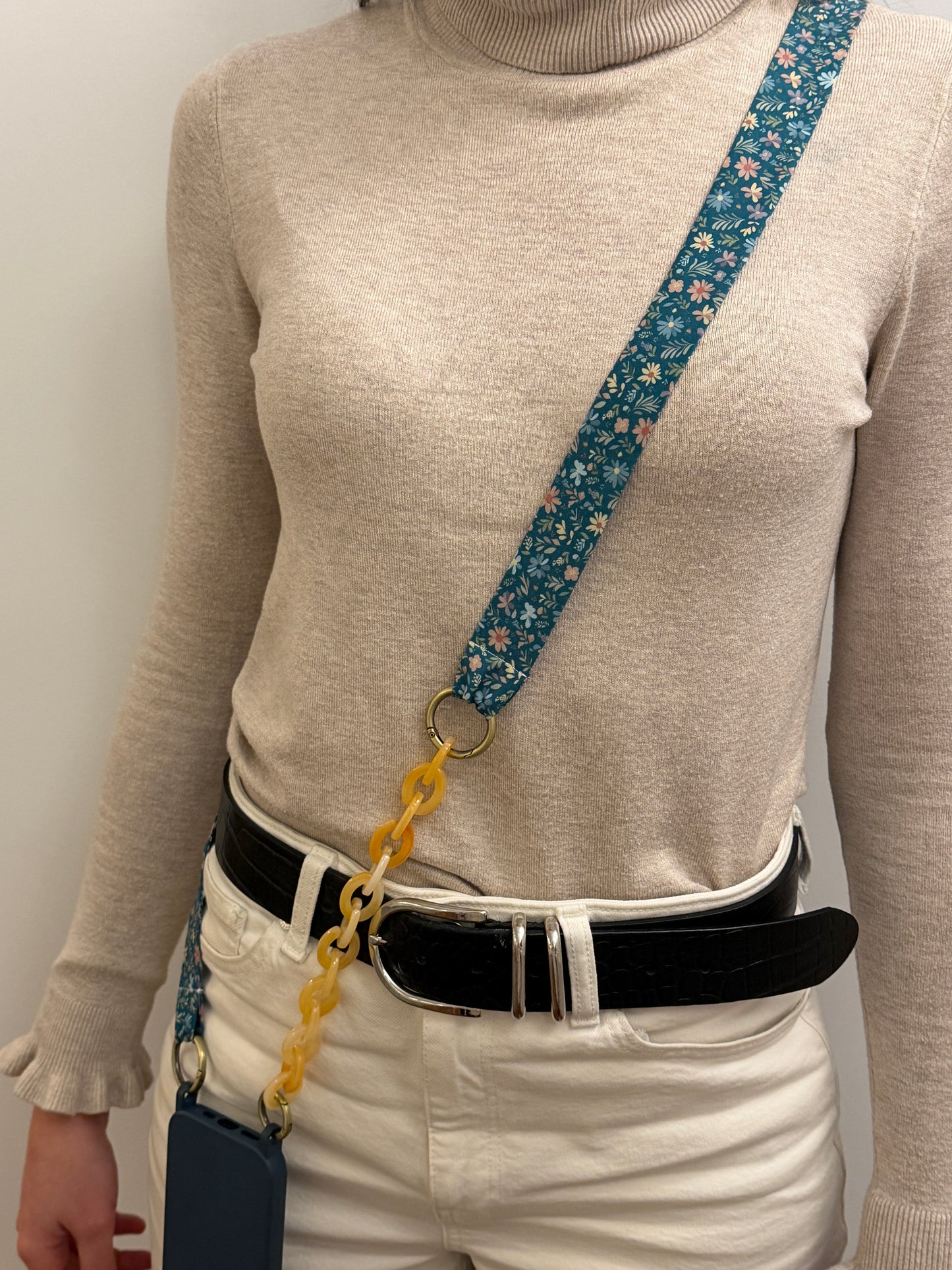 Cuelgamóvil con tela de color azul con flores y con eslabones en color beige. Ajustable y con arandelas de acero inoxidable.