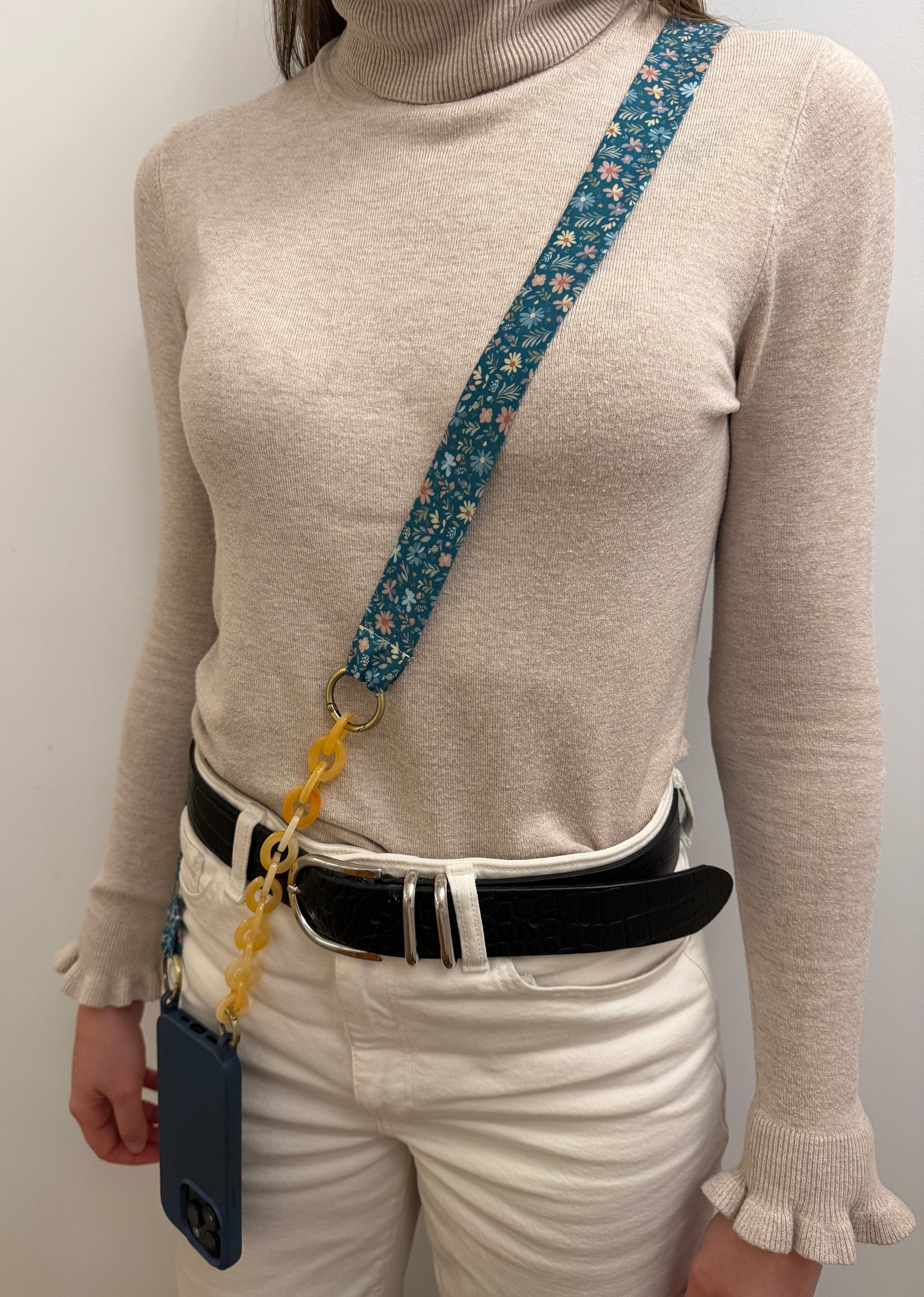 Cuelgamóvil con tela de color azul con flores y con eslabones en color beige. Ajustable y con arandelas de acero inoxidable.