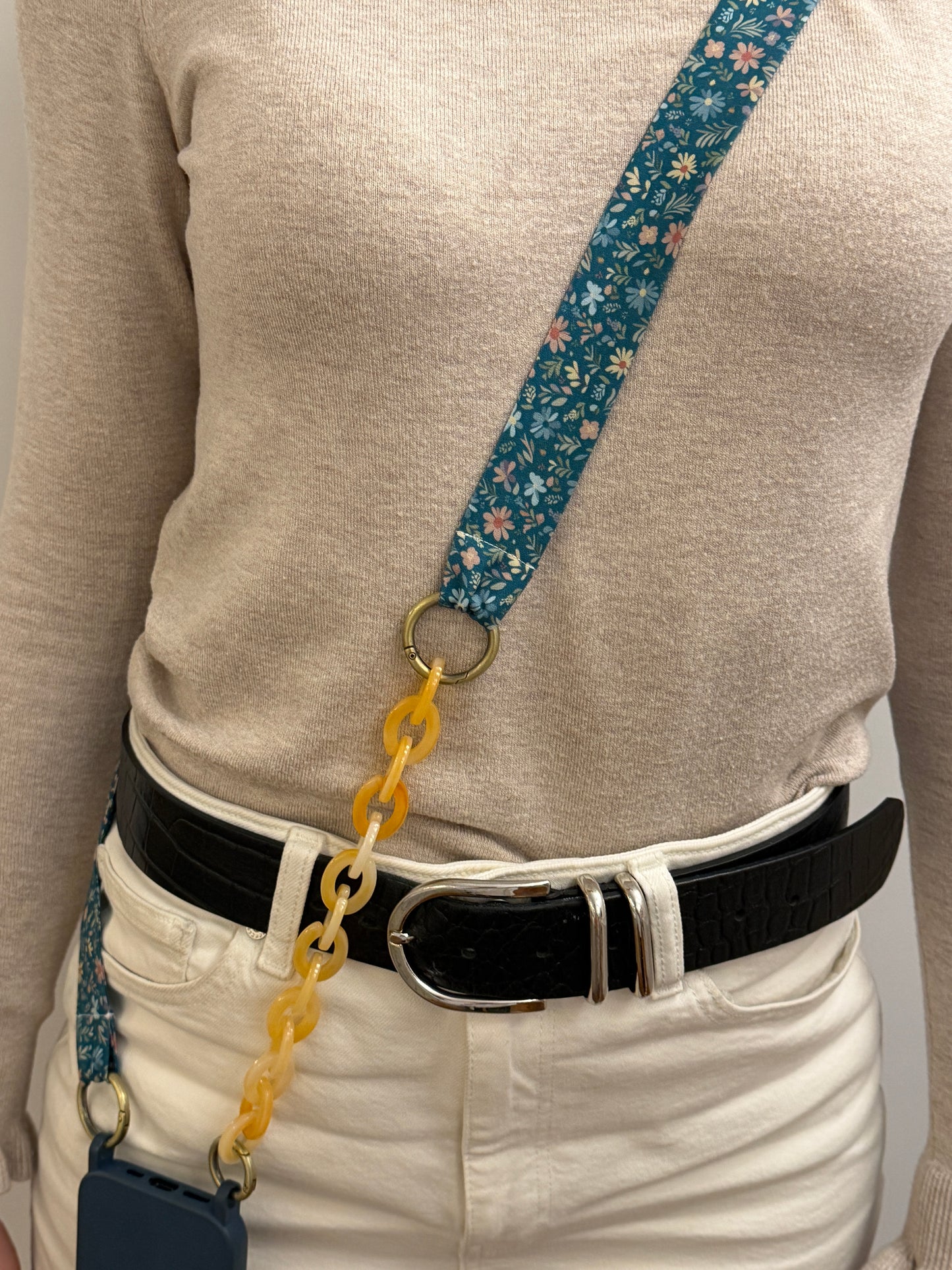 Cuelgamóvil con tela de color azul con flores y con eslabones en color beige. Ajustable y con arandelas de acero inoxidable.