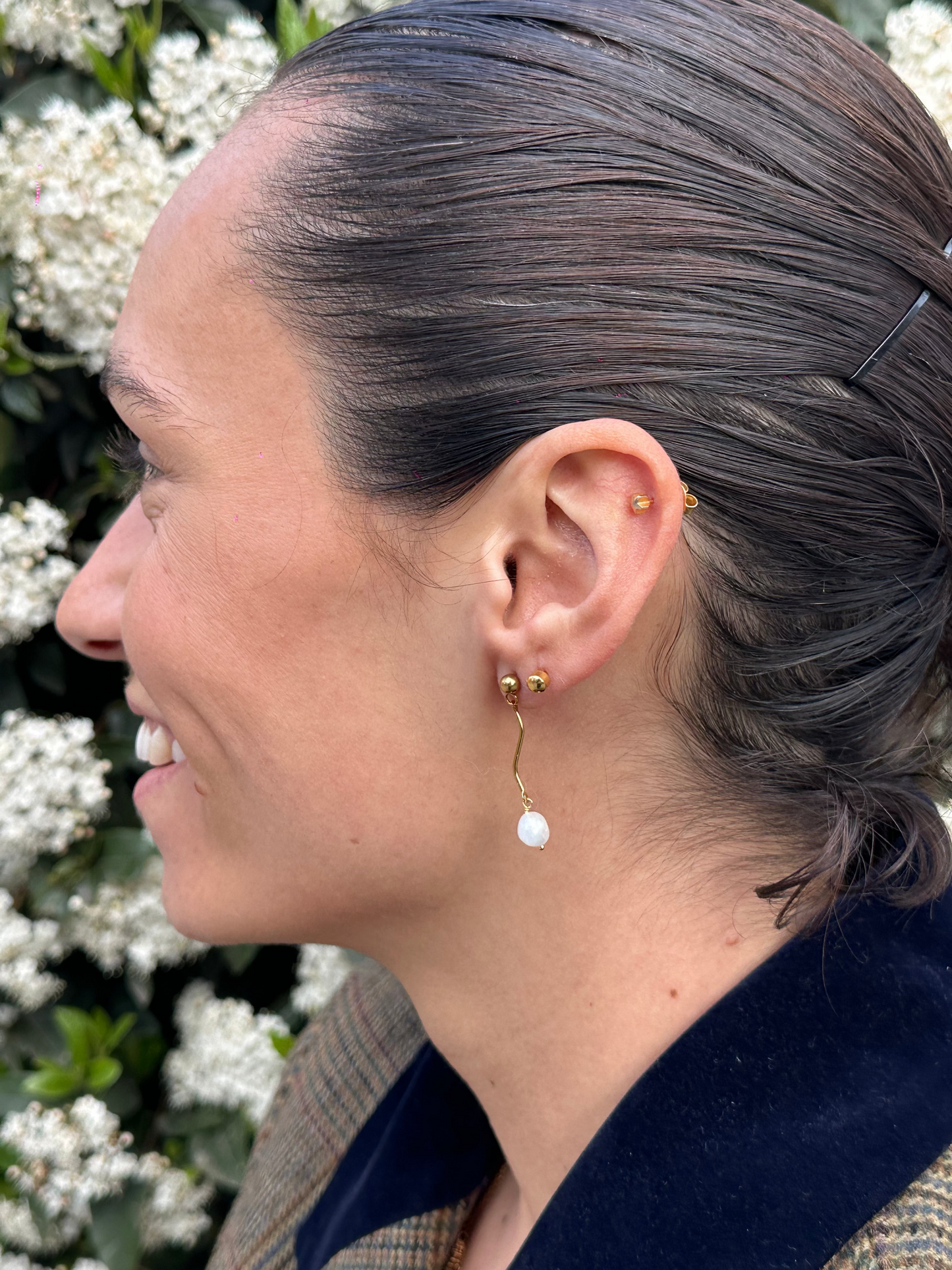 Pendientes de acero inoxidable en color dorado con onda y una perla. Estos pendientes son perfectos para elevar tus looks. 