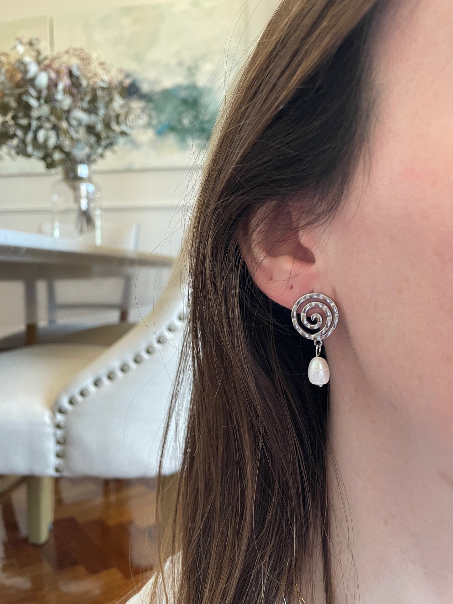 Pendientes de acero inoxidable en color plateado con espiral y una perla. Estos pendientes son perfectos para elevar tus looks. 