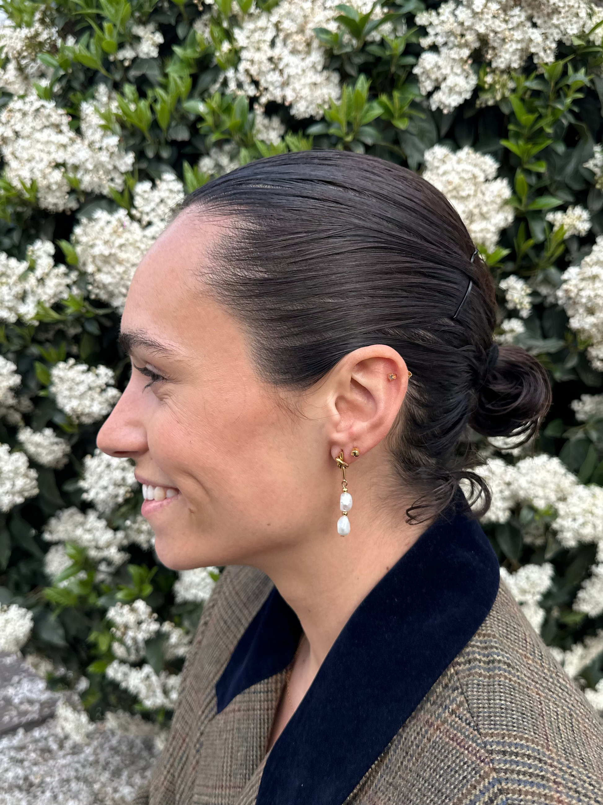 Pendientes de acero inoxidable en color dorado con dos perlas de río. Cierre con forma de nudo. Estos pendientes son perfectos para elevar tus looks. 