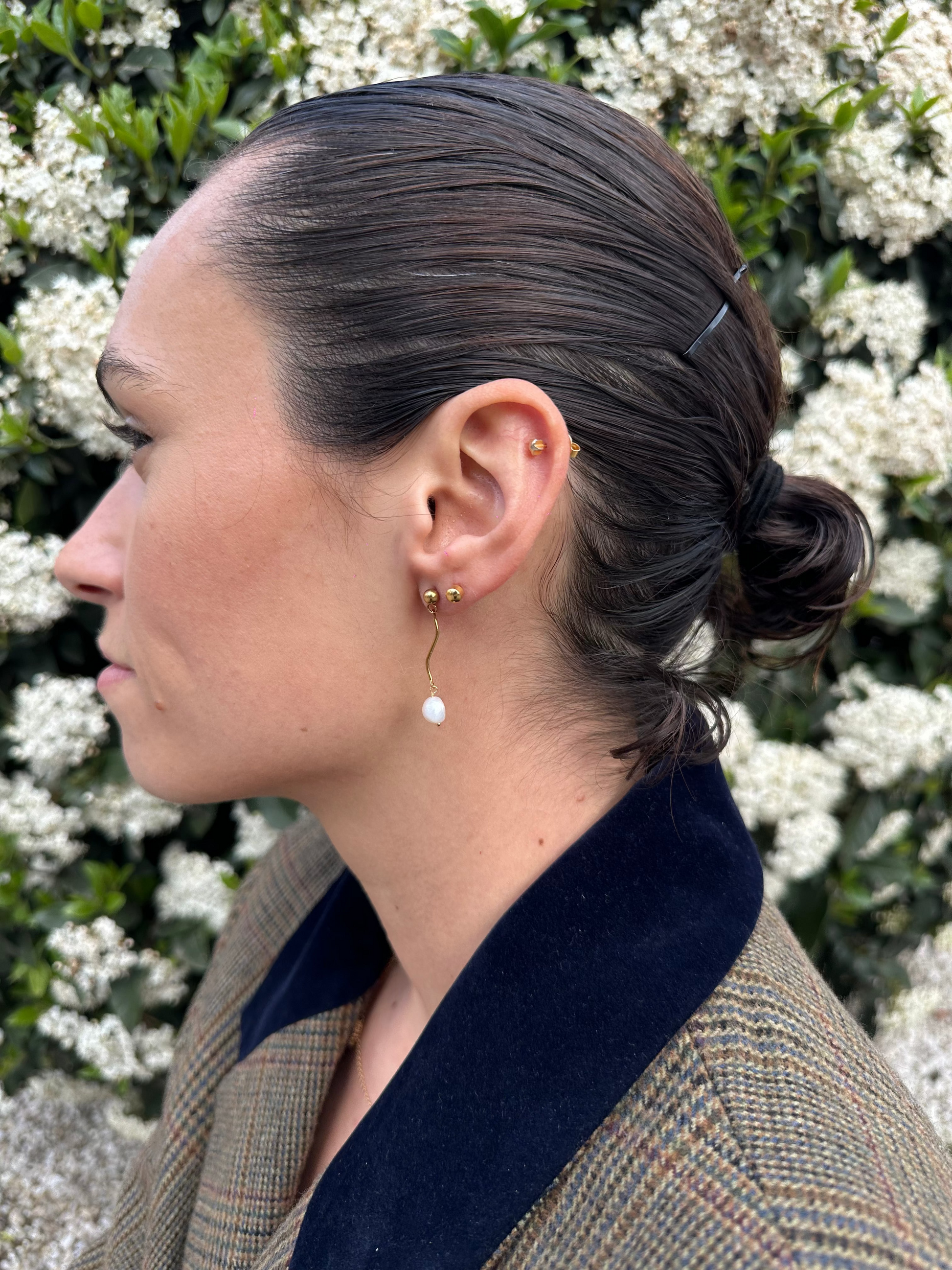Pendientes de acero inoxidable en color dorado con onda y una perla. Estos pendientes son perfectos para elevar tus looks. 