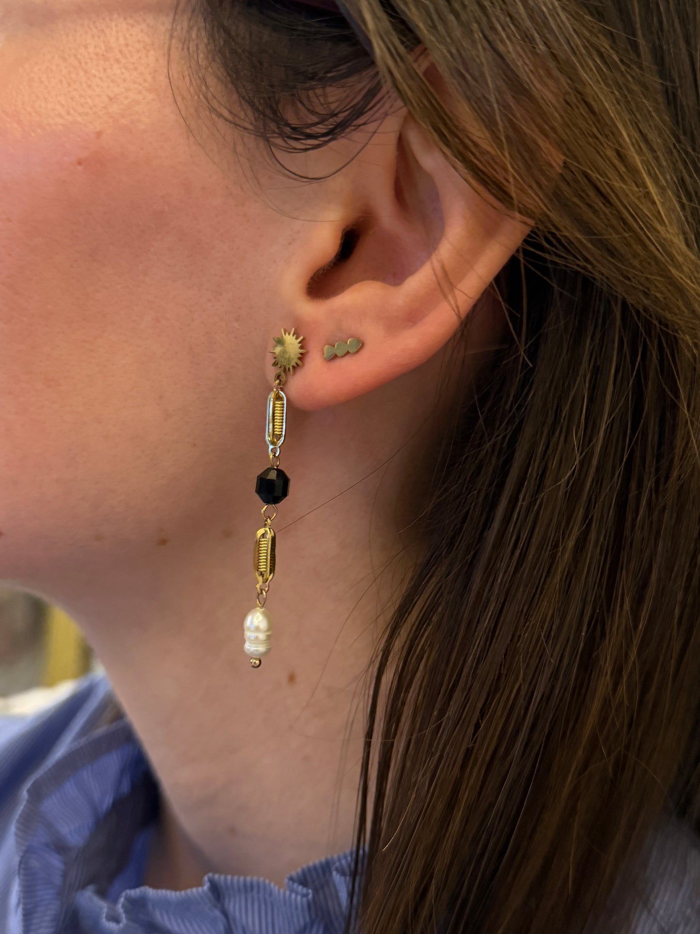 Pendientes largos de acero inoxidable en color dorado con perla de río colgando. Estos pendientes son perfectos para elevar tus looks. 