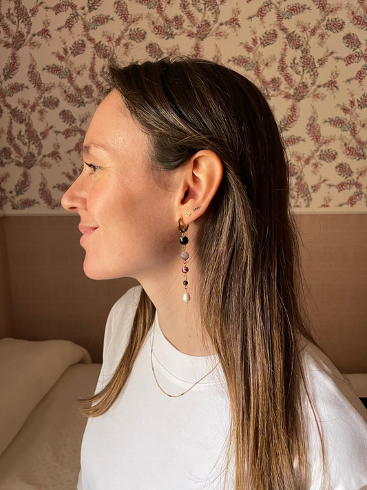 Pendientes de acero inoxidable en color dorado largos con piedras de colores y una perla. Estos pendientes son perfectos para elevar tus looks. 