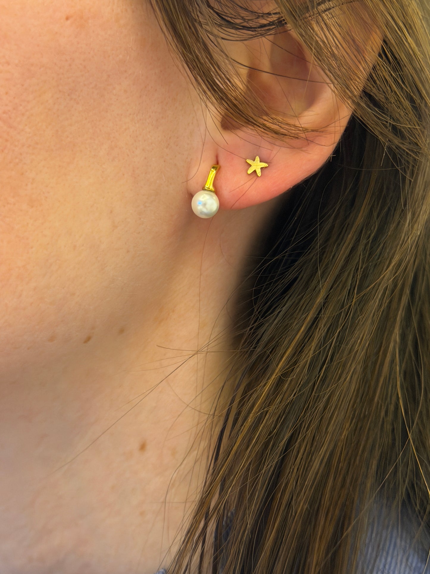 Pendientes pequeños de acero inoxidable en color dorado con perla de río. Estos pendientes son perfectos para elevar tus looks. 