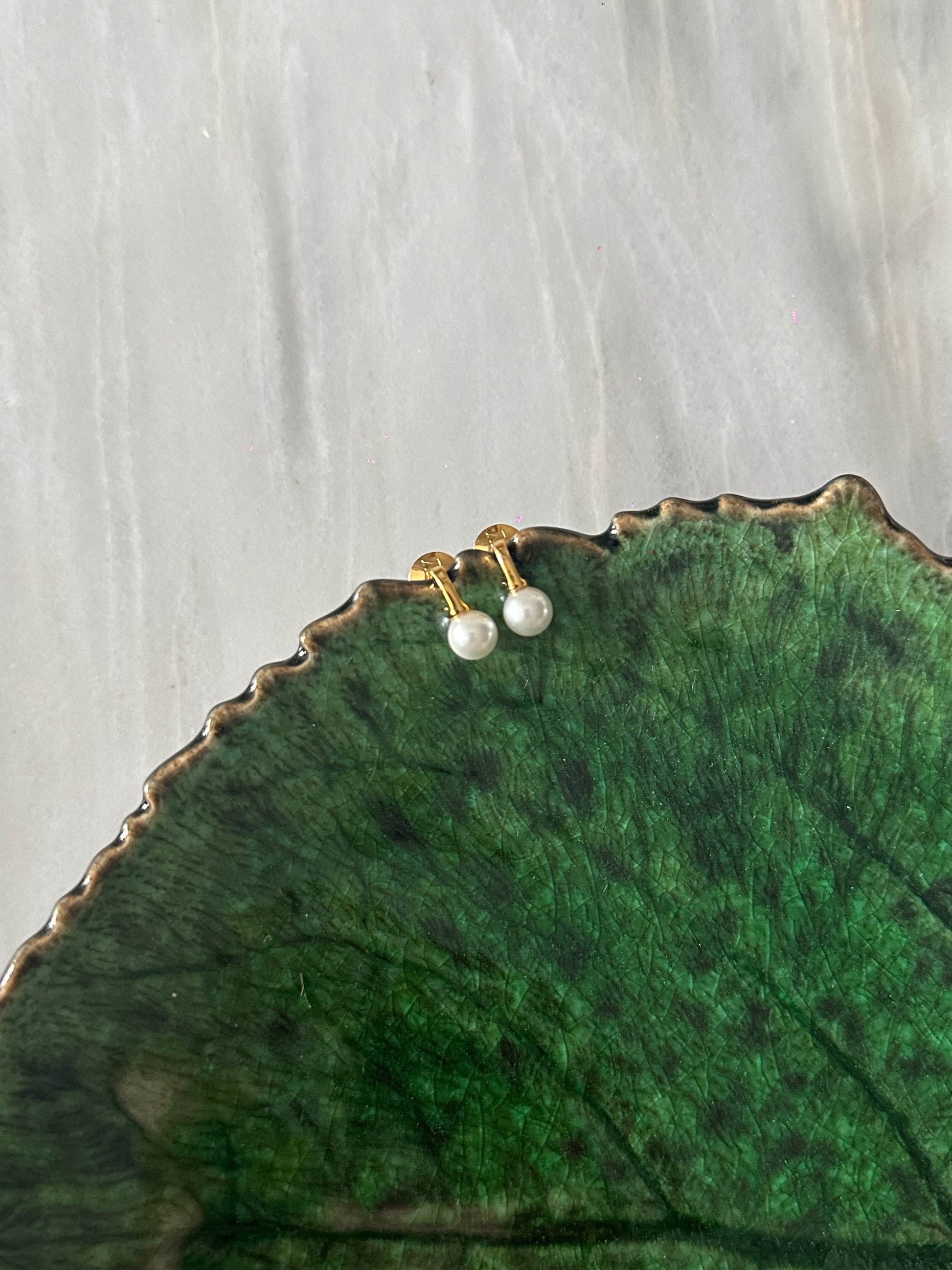 Pendientes pequeños de acero inoxidable en color dorado con perla de río. Estos pendientes son perfectos para elevar tus looks. 