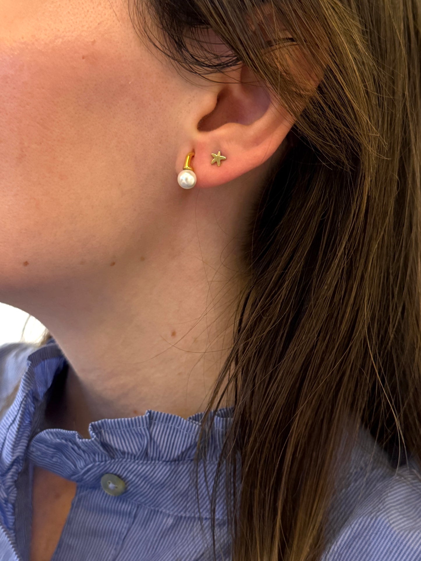 Pendientes pequeños de acero inoxidable en color dorado con perla de río. Estos pendientes son perfectos para elevar tus looks. 