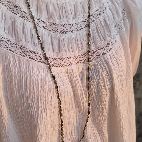 Collar largo con cuentas de cristal en dorado y en negro muy especial, con posibilidad de dar varias vueltas. Acero inoxidable.